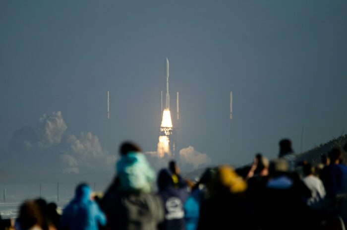 a crowd of people watching a rocket launch